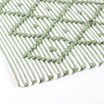 close up look of A green accent rug with a diamond pattern on it