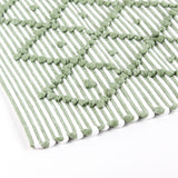 close up look of A green accent rug with a diamond pattern on it