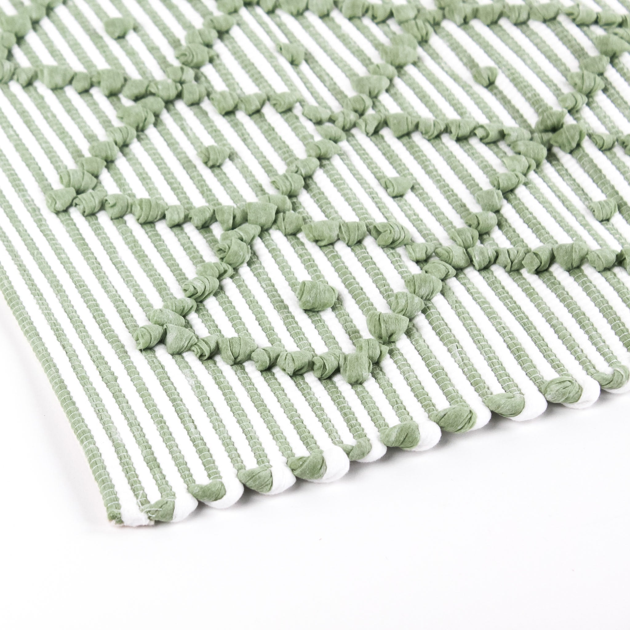 close up look of A green accent rug with a diamond pattern on it