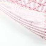 reverse of a pink accent rug with a diamond pattern on it