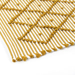 close up look of A yellow accent rug with a diamond pattern on it