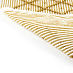 reverse side of A yellow accent rug with a diamond pattern on it