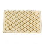 A yellow accent rug with a diamond pattern on it