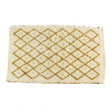 A yellow accent rug with a diamond pattern on it
