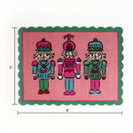 PInk and green christmas rug featuring three nutcrackers and a green scalloped border dimension