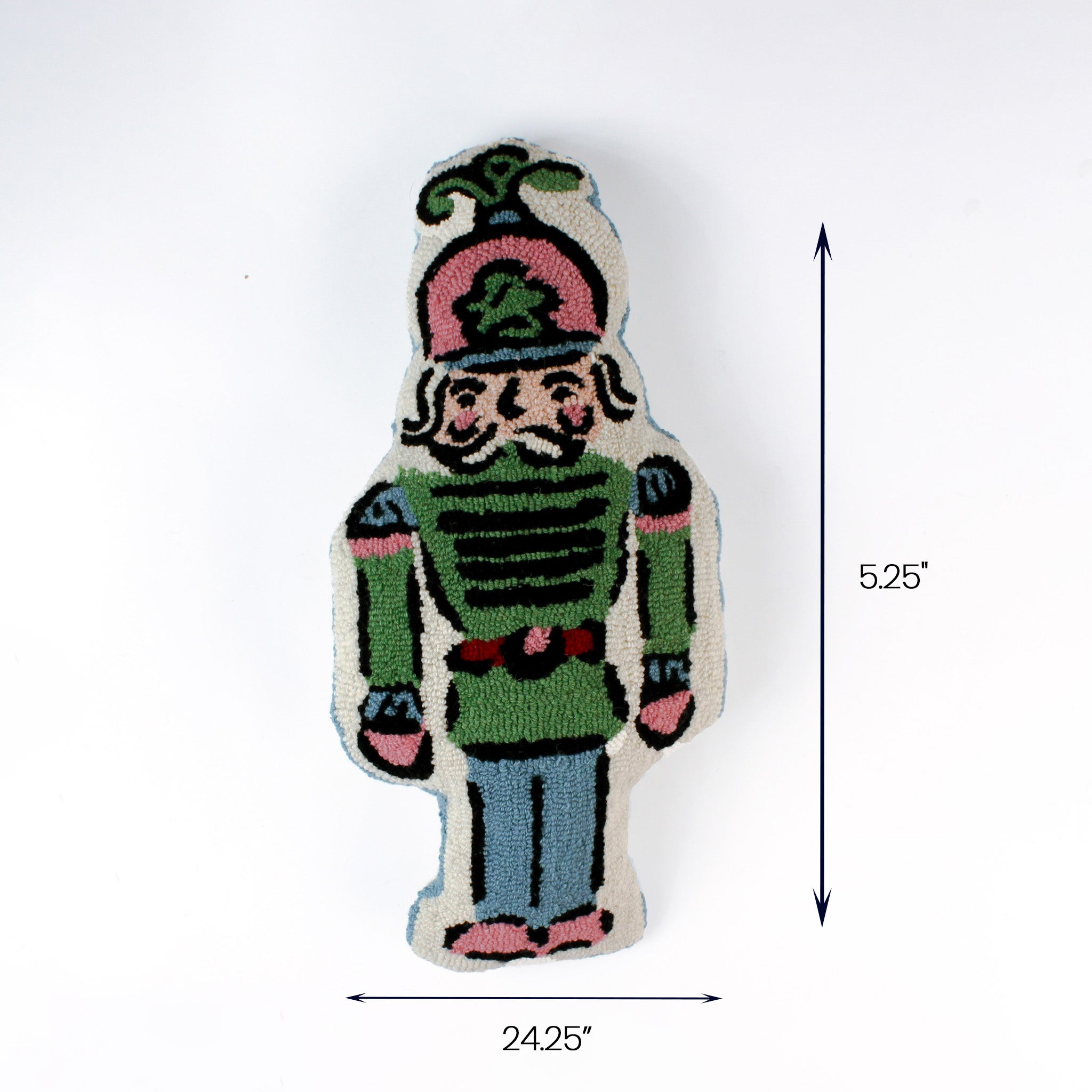 Nutcracker-shaped decorative pillow in green blue and pink tones shown with 24.25 inch length and 5.25 inch height.