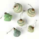 Set of green and cream paper-mâché style Christmas ornaments in assorted shapes shown with one measuring about 3.5 inches tall and 3.5 inches wide.