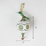 Green and white Christmas ornament with bow and gold hanger, measuring 4 inches tall and 7 inches wide.