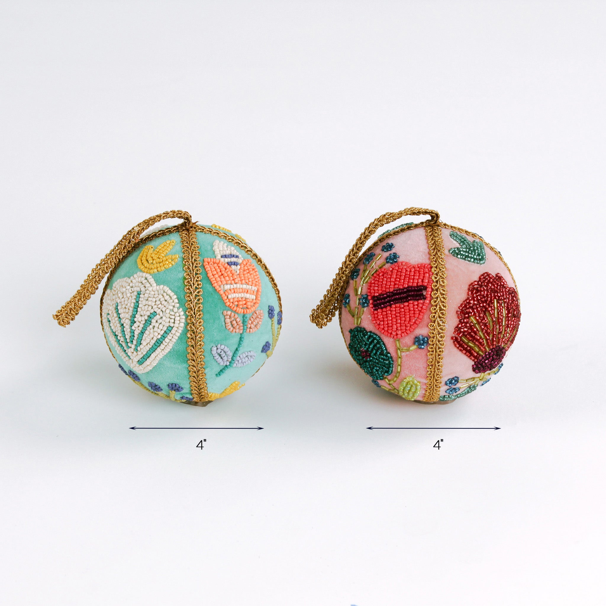 Two decorative beaded Christmas ball ornaments, one in teal and one in pink, each measuring 4 inches wide.