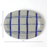 Oval ceramic serving platter with hand-painted blue grid pattern, 14.25 inches long and 10.375 inches wide.