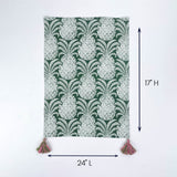 Green and white patterned table runner with tassels on both ends shown with 24 inch length and 17 inch height.
