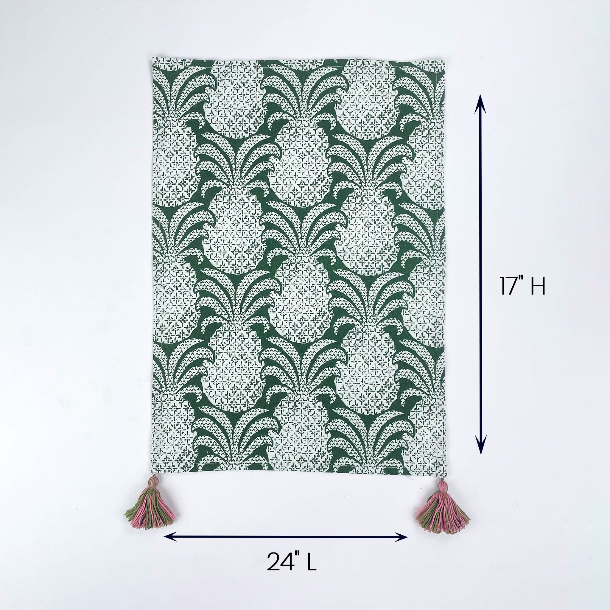 Green and white patterned table runner with tassels on both ends shown with 24 inch length and 17 inch height.