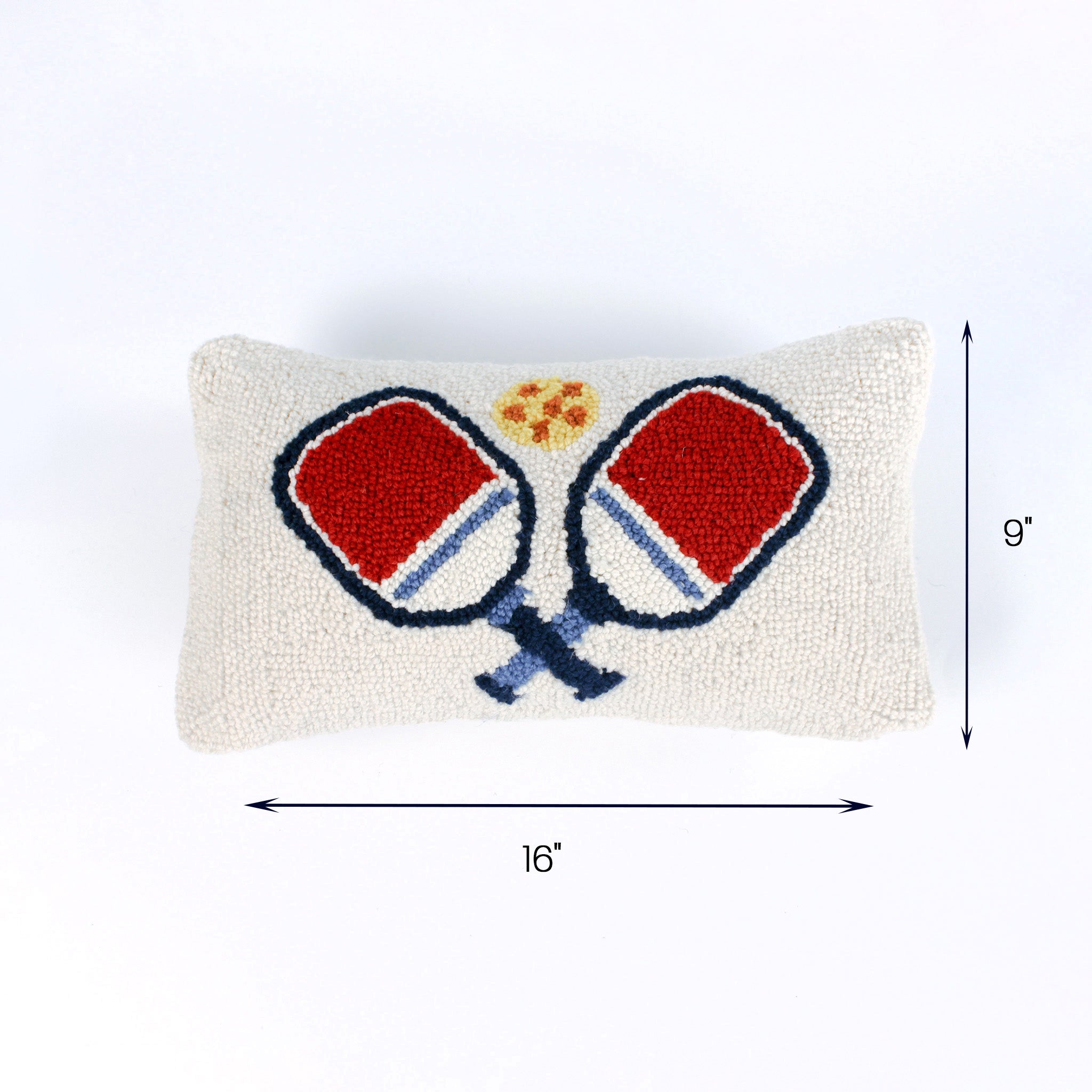 Rectangular hook pillow with red and blue pickleball paddles crossed at the center and a yellow ball above them, measuring 16 inches wide and 9 inches tall.