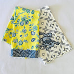 a yellow chinoiserie tea towel and a blue and white chinoiserie tea towel