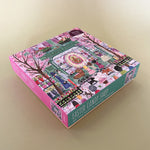 Illustrated 500-piece puzzle showing a colorful candy shop storefront with children and Easter decorations