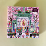 Illustrated 500-piece puzzle showing a colorful candy shop storefront with children and Easter decorations