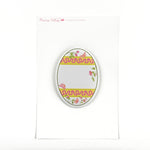 an egg-shaped spring paper place card with a floral and ribbon design on a white background and a pink logo that says Madcap Cottage in the top left corner. 