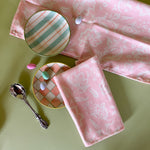 Hampton Court, shell pink cloth dinner napkins with plaid plates, candied eggs on a green background. 