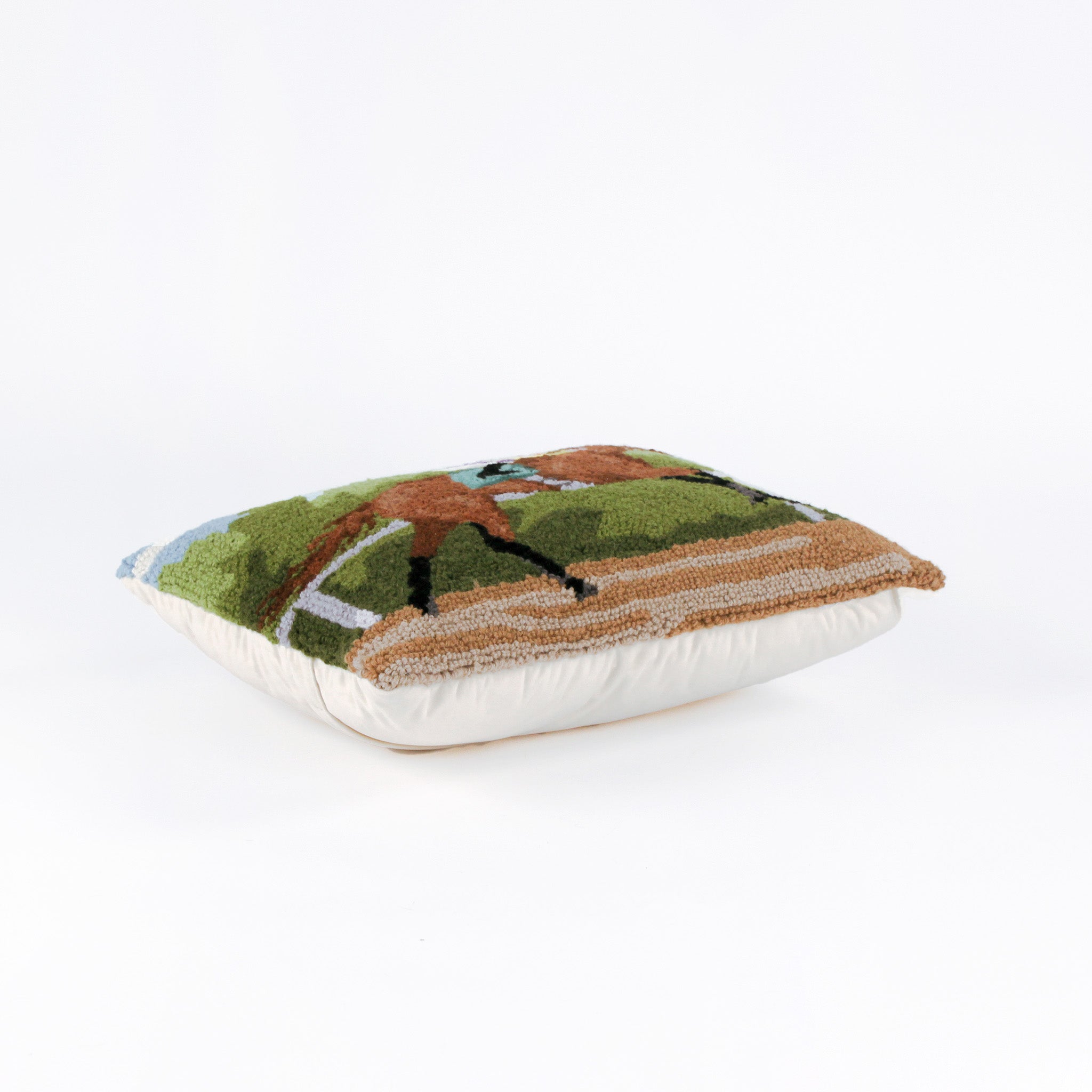 lying hooked wool derby day pillow featuring a brown race horse and hockey against a background of trees and blue sky