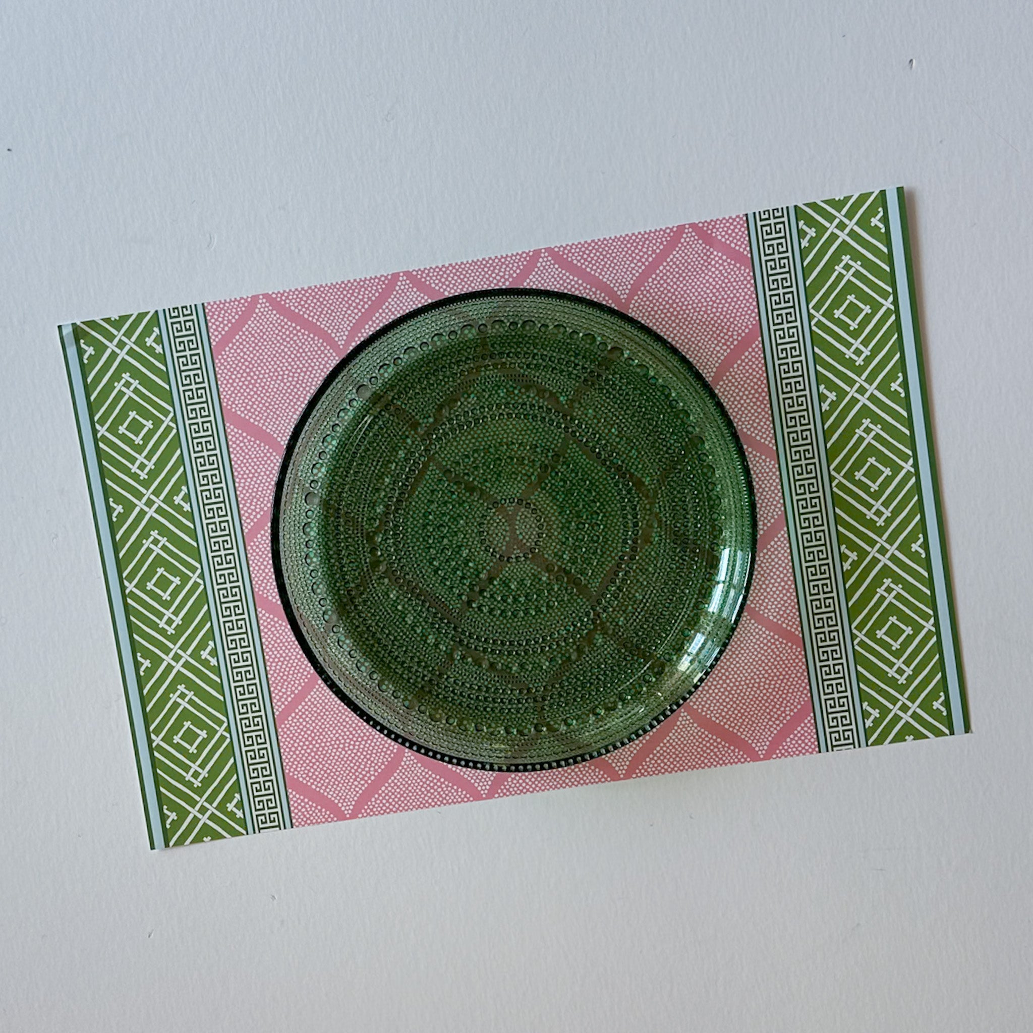 fez pink and green paper placemat with decorative pattern and green plate top view
