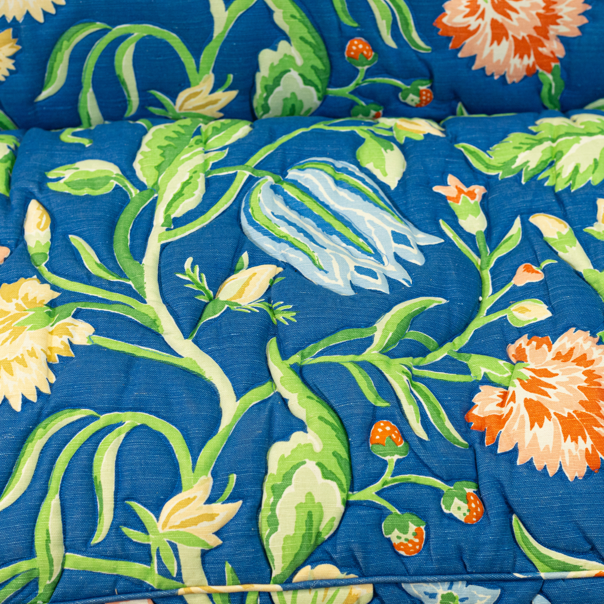 Fabric detail of Blue floral upholstered loveseat with botanical pattern and rolled arms