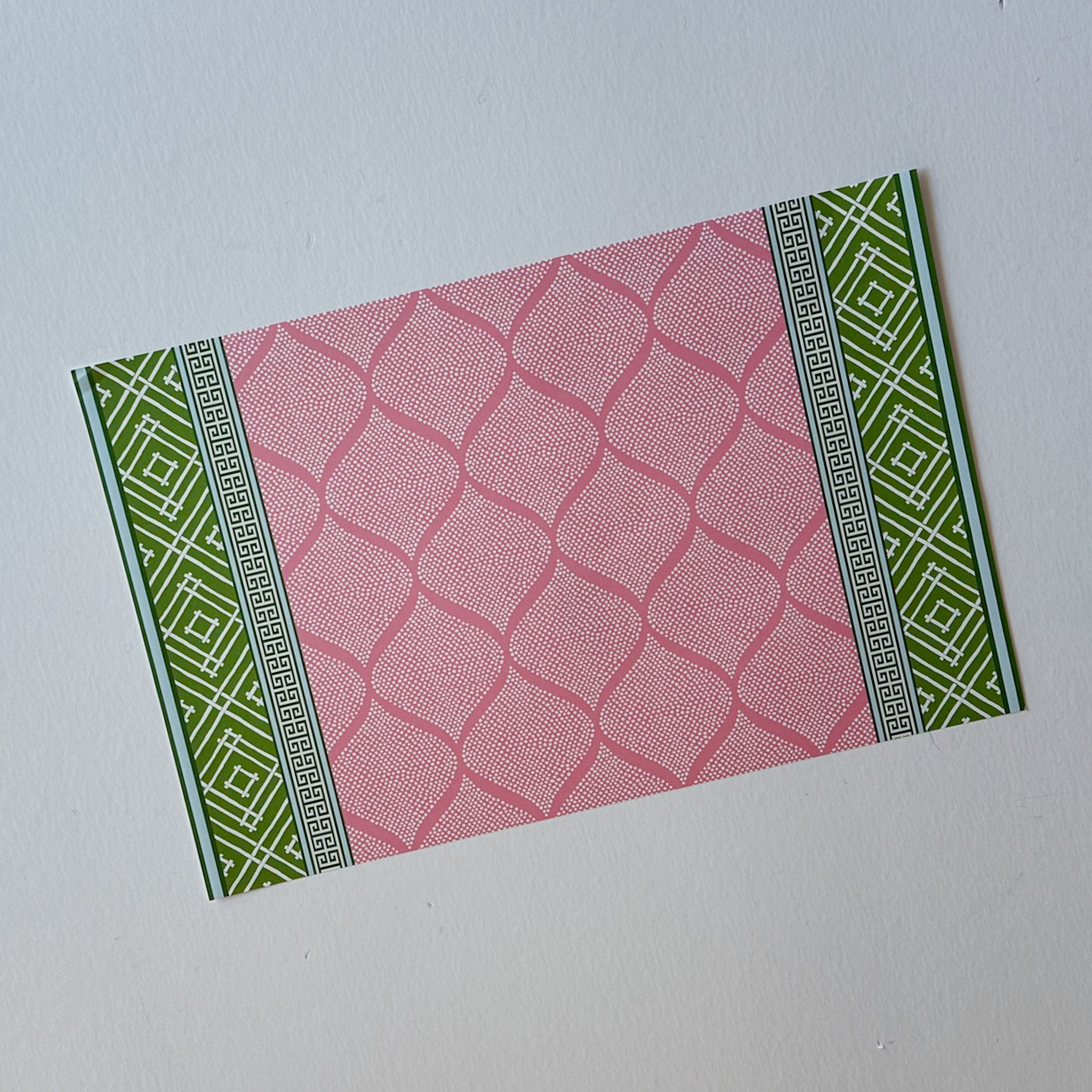 fez pink and green paper placemat with geometric pattern on white background