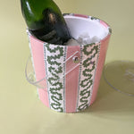 an pink and green acrylic ice bucket filled with ice and a bottle.