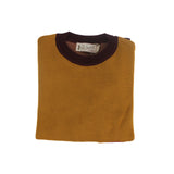 Folded mustard yellow knit sweater with dachshund motif and visible branded label