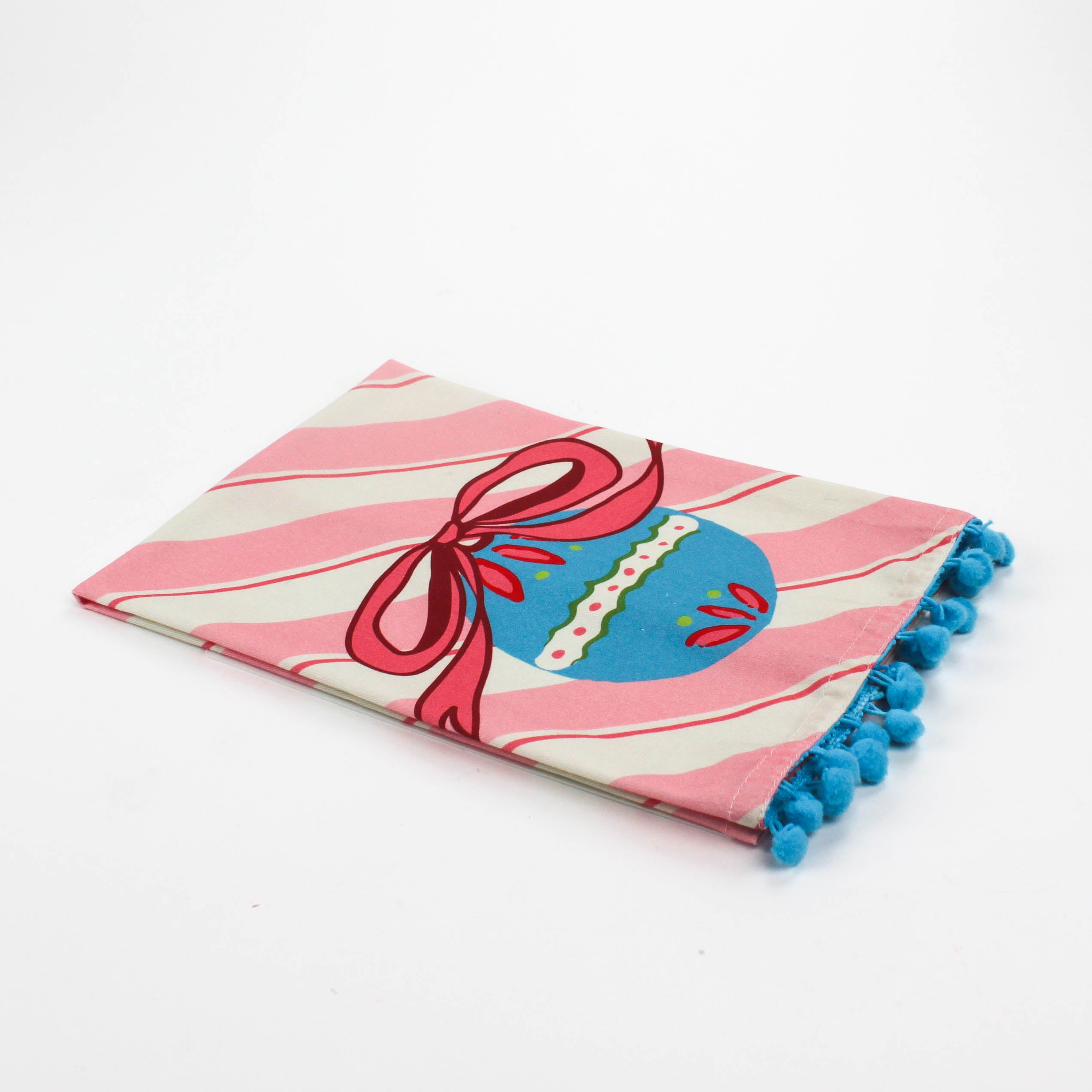 Striped Pink Christmas tea towel with blue pom pom trim folded so that a blue ornament with a pink bow shows 