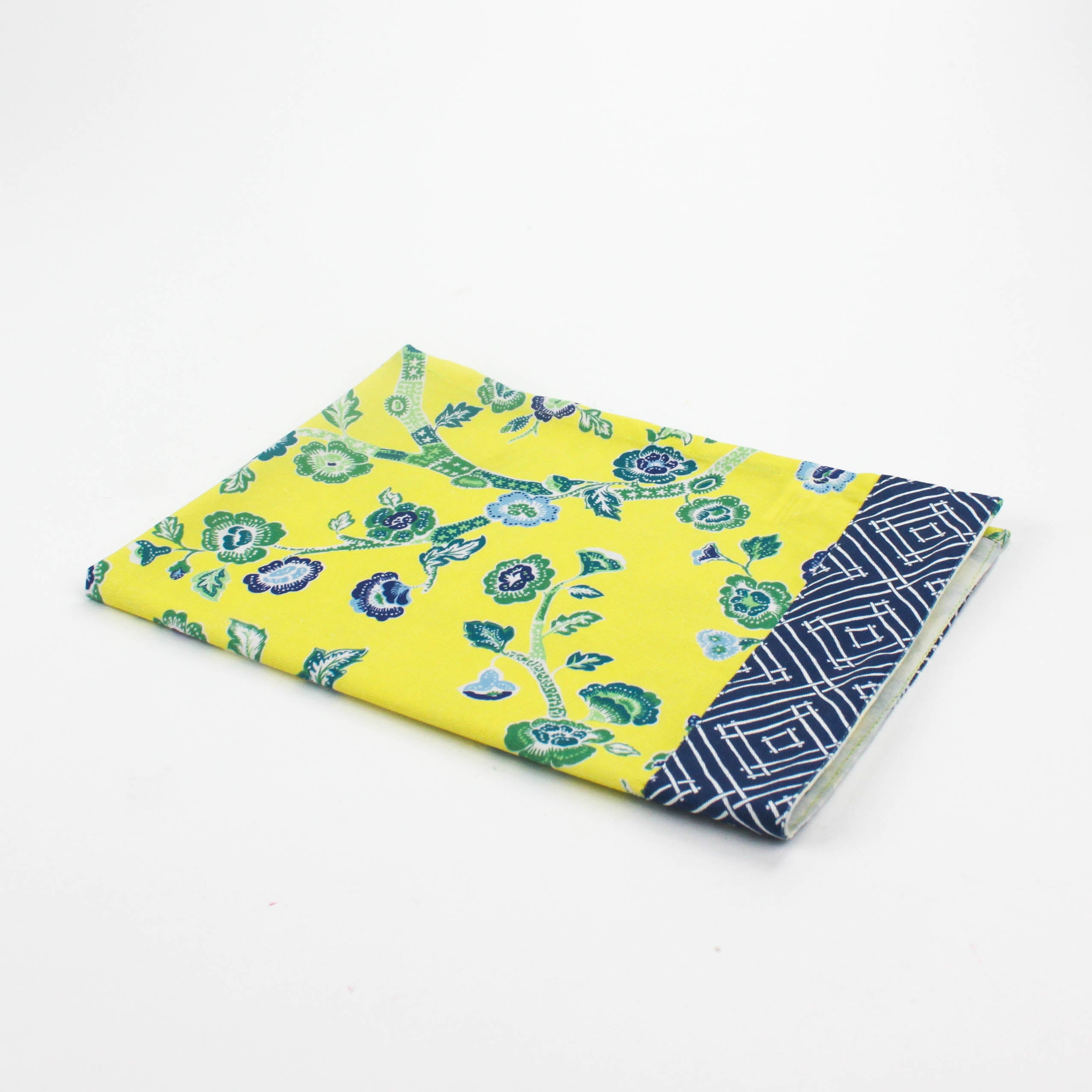 Christmas tea towel with a bright yellow background featuring a blue and green floral chinoiserie pattern