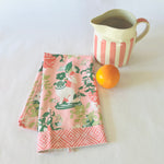 a folded pink chinoiserie tea towel from madcap cottage with pug and vase motifs.