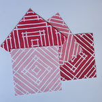 four red and pink paper placemats with a white bamboo design called Island house by Madcap Cottage