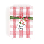 Gift wrapped in red and white gingham paper with green ribbon and Christmas gift tag.