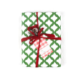 Front view of gift wrapped in green and white patterned paper with red ribbon and plaid gift tag.