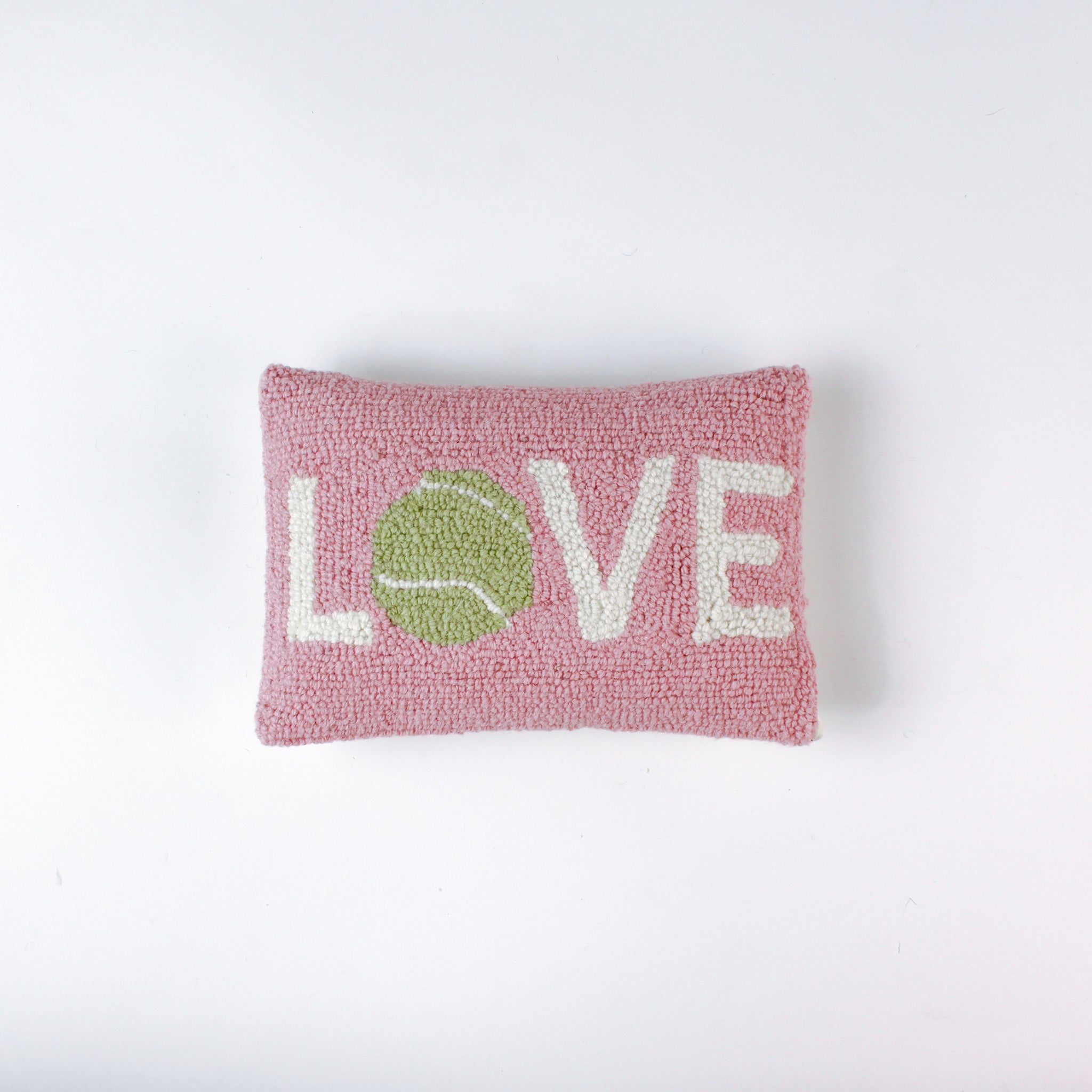 A pink pillow with the word "LOVE," where the "O" is a green tennis ball