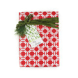 Gift wrapped in red Monserrat patterned paper with green ribbon and holiday gift tag.