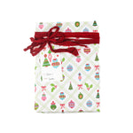 Gift wrapped in white Christmas ornament print paper with red ribbon and gift tag.
