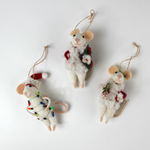 Three white felt mouse ornaments dressed in cozy winter outfits, one wrapped in colorful holiday lights, one holding a Christmas wreath, and one holding a festive ornament