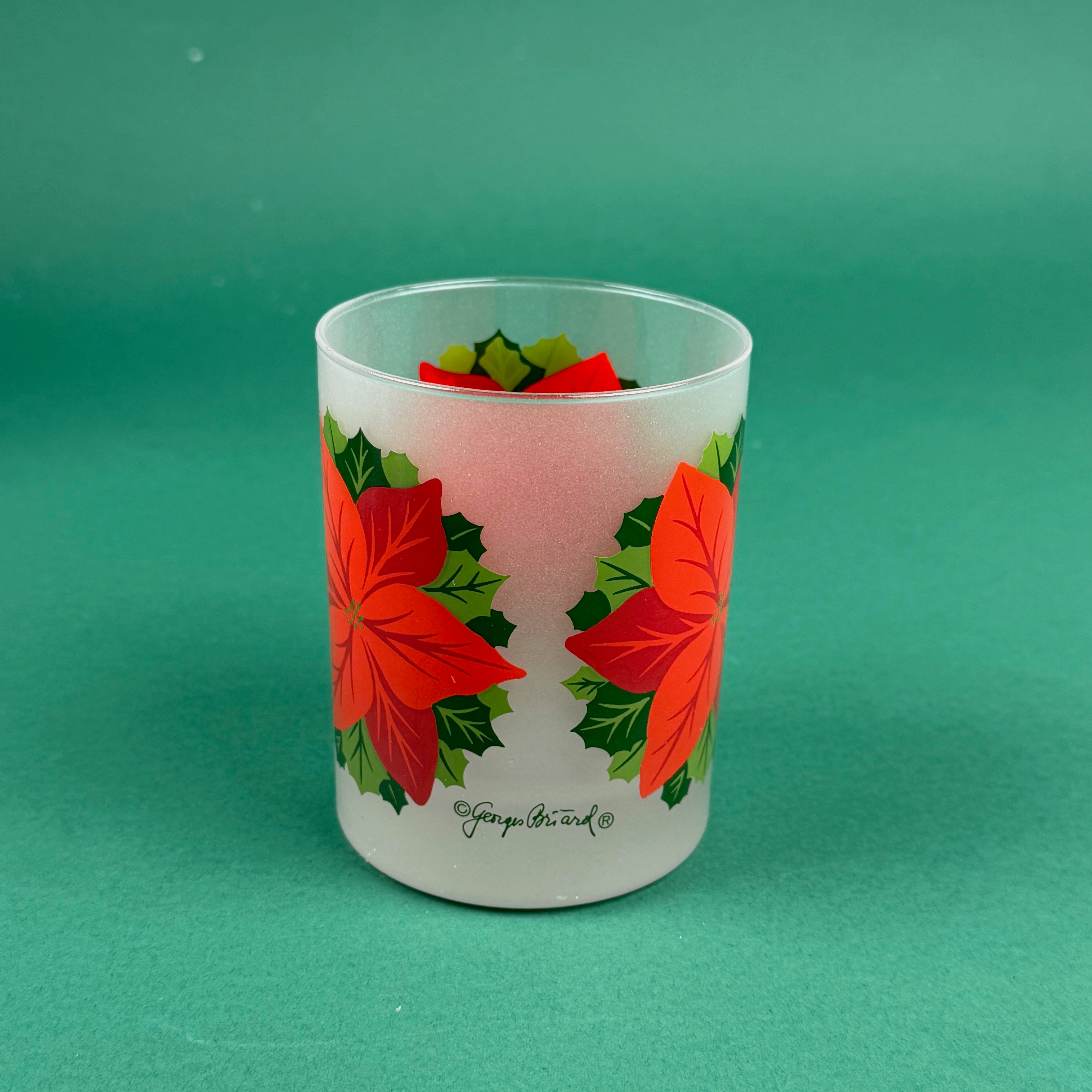 Frosted clear glass with a bright red poinsettia and green holly leaf design on a green background