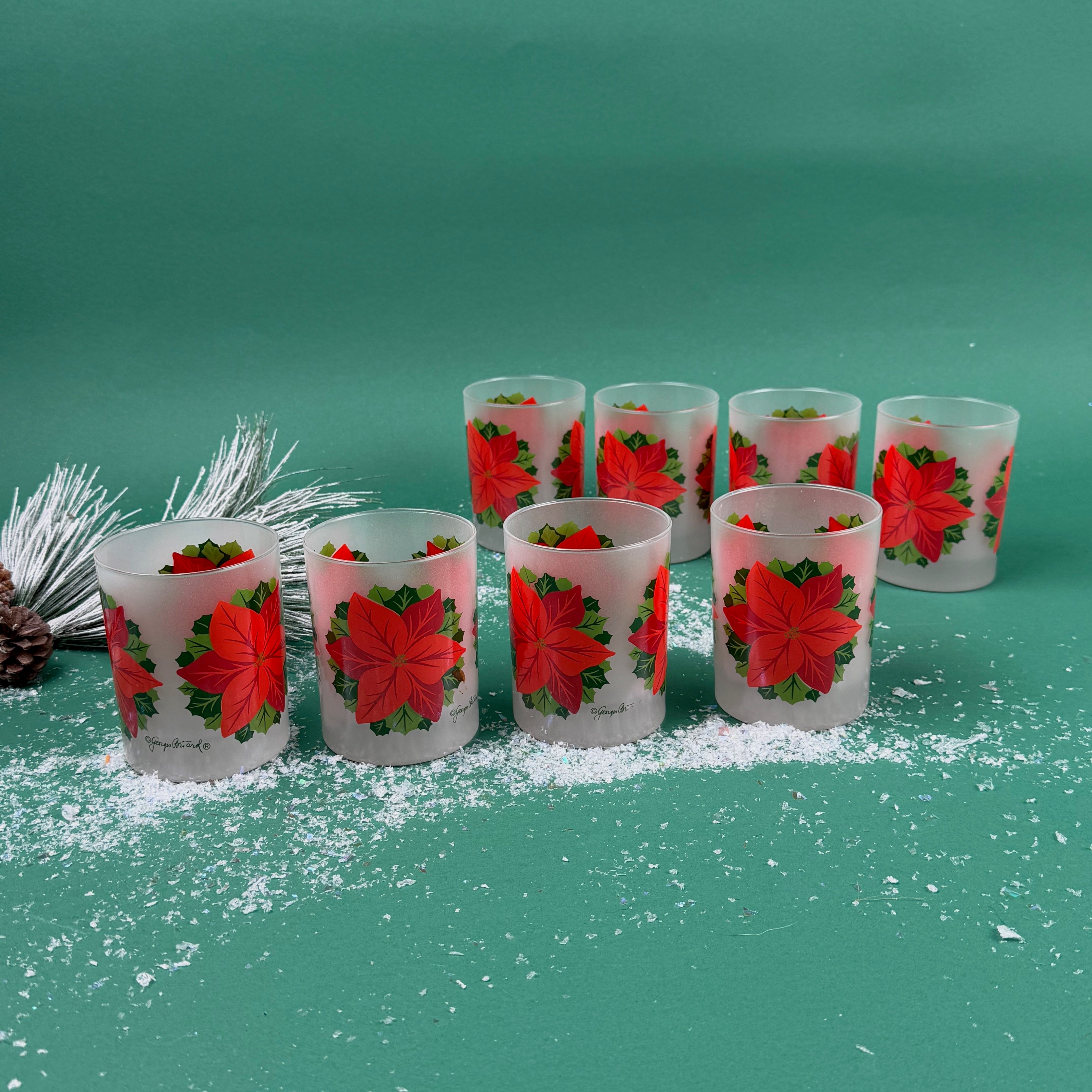 Frosted clear glass  set with a bright red poinsettia and green holly leaf design on a green background