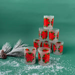 Frosted clear glass set with a bright red poinsettia and green holly leaf design on a green background
