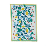a lemon and strawberry tea towel with blue flowers and a yellow and green border against a white background. 