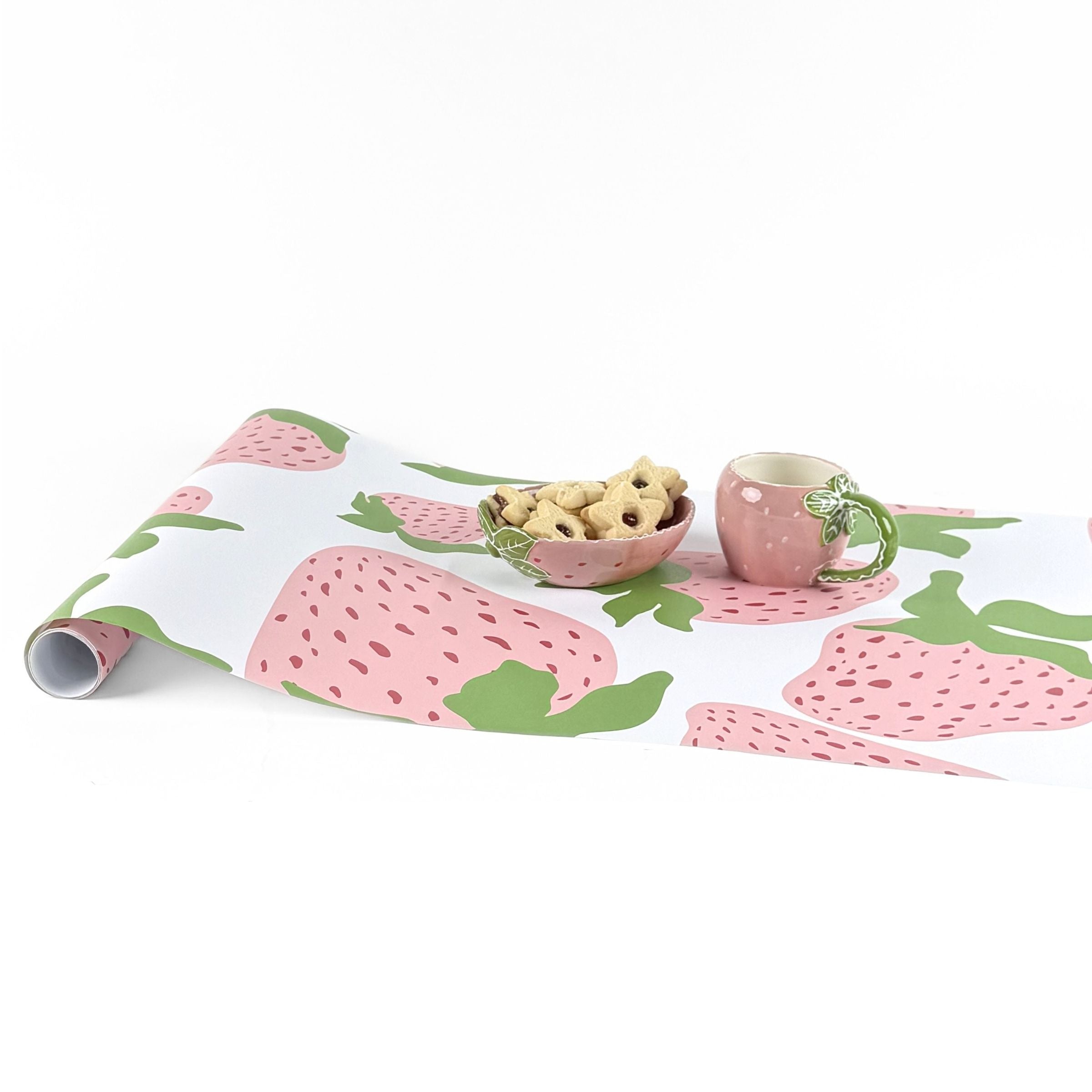 Garden strawberry pink green paper table runner styled with matching mug and bowl.