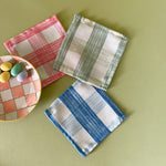 Three Gin Lane gingham cloth cocktail napkins with small plate of candy eggs.