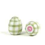 a pair of green gingham decorative Easter eggs on white background, with one egg showing the bottom part