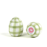 a pair of green gingham decorative Easter eggs on white background, with one egg showing the bottom part