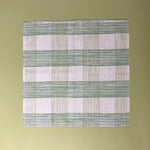 a green  gingham dinner napkins in gin lane print fabric by madap cottage on a light green background.