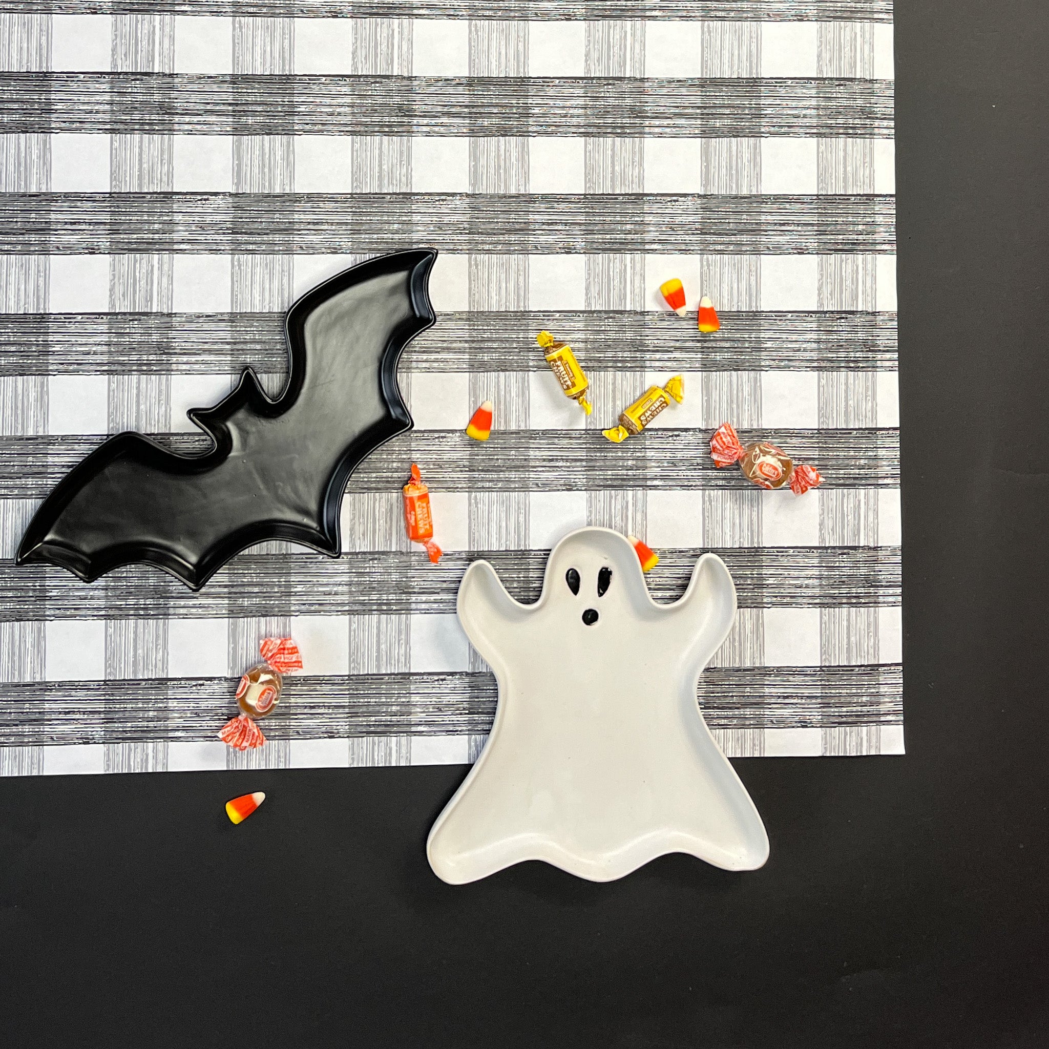 a black  halloween paper table runner in a black and white gingham pattern from madcap cottage with halloween treat on top