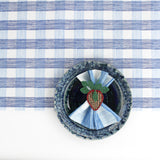 a ceramic plate on top of a Gin Lane Blue Gingham Paper Table Runner on a white background