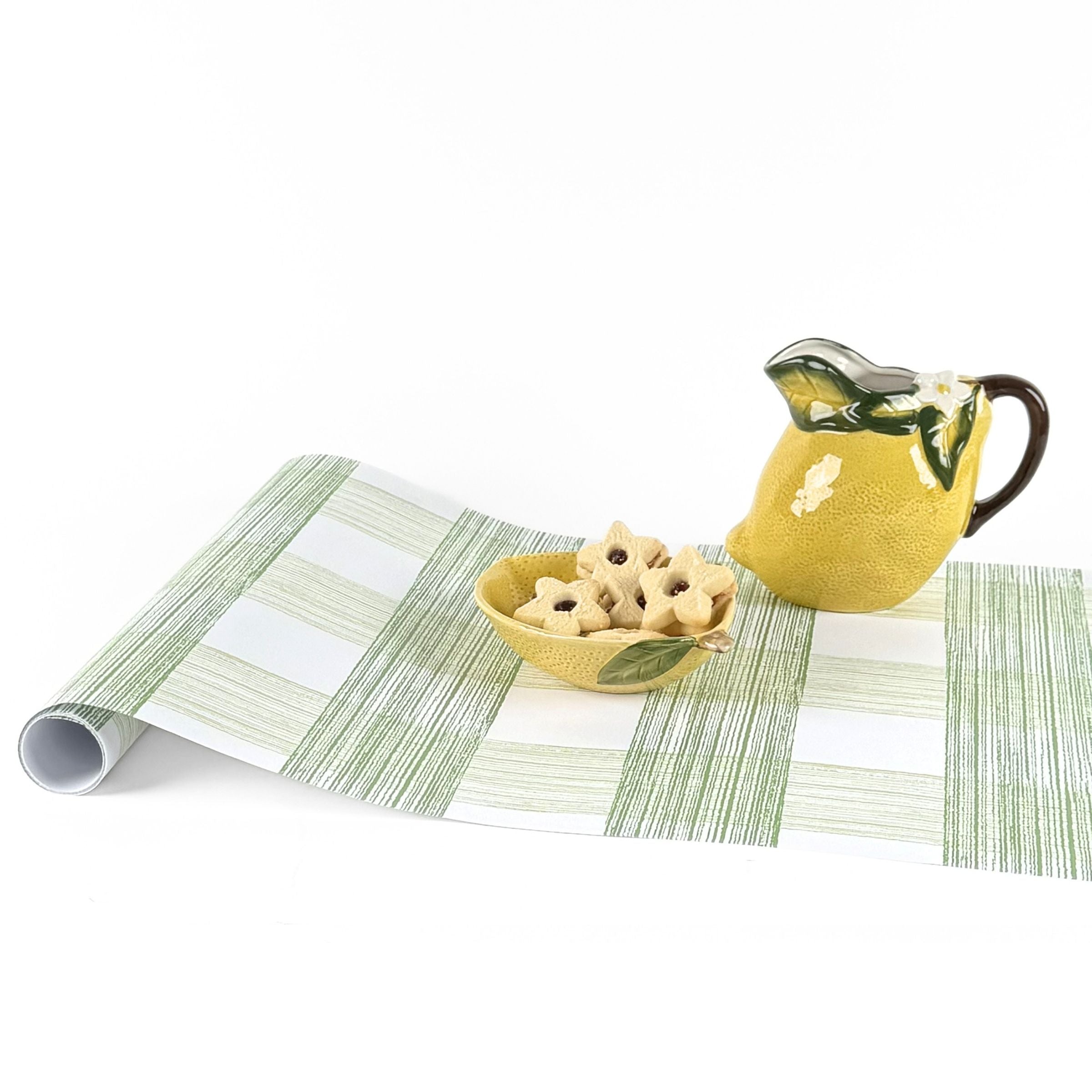 Gingham green paper table runner styled with lemon pitcher and decorative bowl.